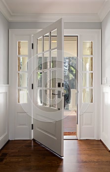 Vertical shot of an open, wooden front door photo