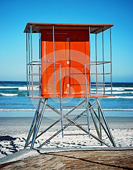 Vertical shot of an orange beach lifeguard hut near the sea