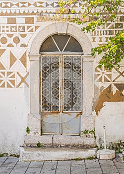 Vertical shot of an ornamented door and painted wall with geometric patterns in Pyre, Chios, Greece