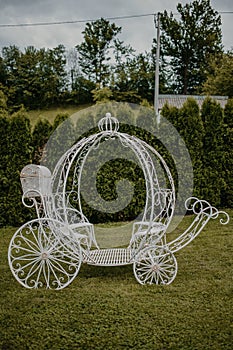 Vertical shot of an outdoor wedding ceremony decorative carriage