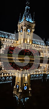 Vertical shot of the palace of culture in Iasi reflected on the water at night, Romania