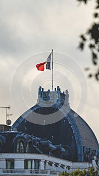 Vertical shot of the palace tower with France flag on the clou sky background