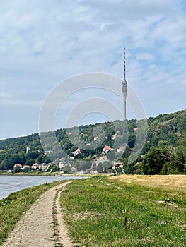 Vertical shot of a pathway at a lake on the background of the Fernsehturm Dresden