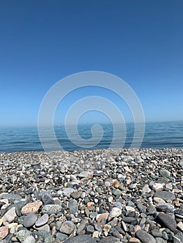 Vertical shot of a pebbled beach against a blue sea in Batumi, Georgia on a clear summer day