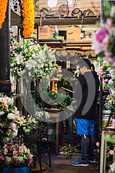 Vertical shot of people choosing flowers in the flower market