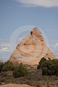 Vertical shot of a person climbing a rock in Moab, Utah, US