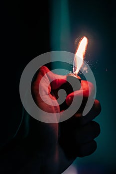 Vertical shot of a person hand holding a lit lighter