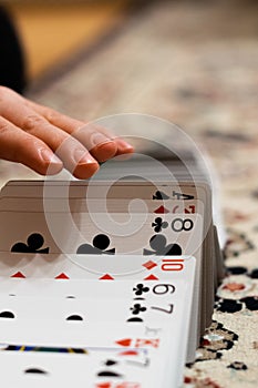Vertical shot of person's hands shuffling the card deck on the table