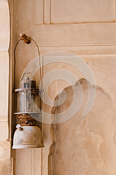 Vertical shot of a petromax kerosene lantern hang on the door of a Buddhist building photo