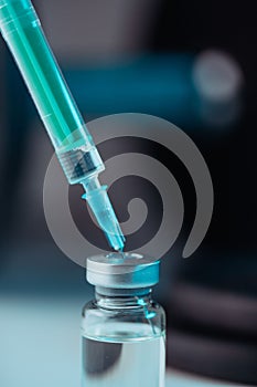 Vertical shot of pharmaceutical syringe with needle in a medicine and pills - illegal doping drugs