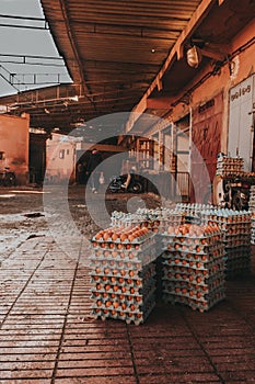 Vertical shot of piles of eggs in cartons put outdoors in front of a market