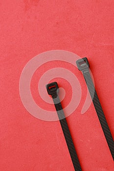 Vertical shot of plastic clamps isolated on a red background