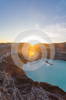 Vertical shot of Poas Volcano Crater at sunrise surrounded by volcanic rocks in Poas Volcano National Park in Alajuela province of