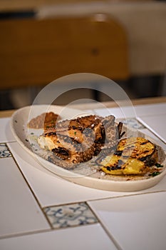 Vertical shot of a Polvo a Lagareiro served in a white oval plate photo