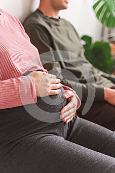 Vertical shot of a pregnant woman stroking her belly