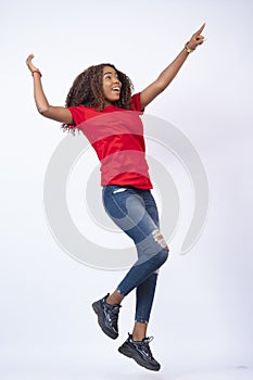 Vertical shot of a pretty young African woman wearing a red top and blue jeans