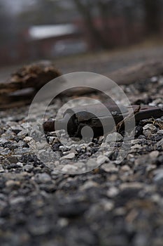 Vertical shot of random metal rusty scrap on rocky surface outdoors on the blurred background