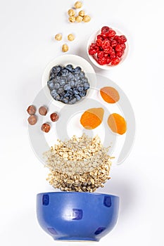 Vertical shot of a raw oatmeal, dried berries and nuts