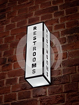 Vertical shot of a rectangular "RESTROOMS" sign with white led lights on the wall