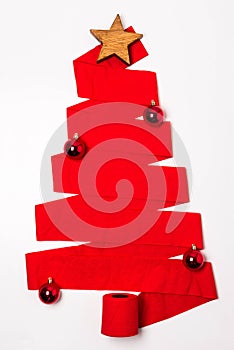 Vertical shot of a red Christmas tree made from a toilet paper roll with ornaments under the lights