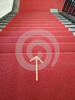 Vertical shot of a red stairway with the direction marked on the ground