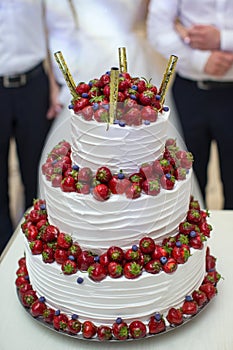 Vertical shot of a red and white wedding cake with fresh strawberries decoration