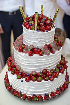 Vertical shot of a red and white wedding cake with fresh strawberries decoration