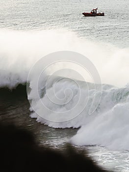 Vertical shot of restless sea scenery with lofty waves and a boat on its surface-perfect wallpaper