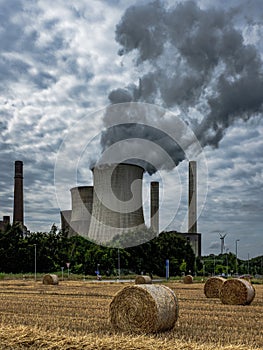 Vertical shot of rising smoke making the air polluted and hayricks in the field