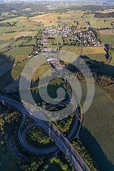 Vertical shot of a road interchange with a town and fields in the background