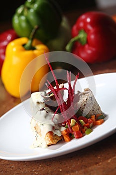 Vertical shot of roast chicken served with risotto and fresh vegetables on a white plate