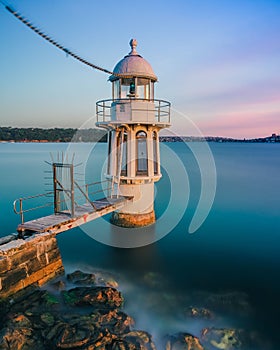 Vertical shot of Robertson Point Light in Sydney surrounded by blue water in the evening