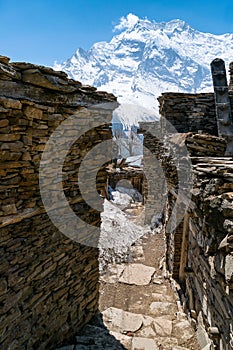 Vertical shot of the rocky stone walls in Annapurna circuit trek, Ghyaru in Nepal under blue sky photo