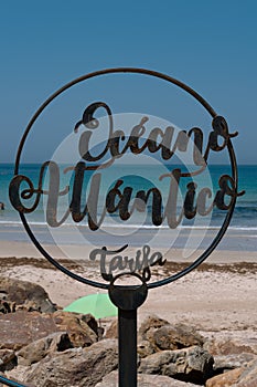 Vertical shot of a Oceano Atlantico Tarifa - Atlantic Ocean Tarifa sign on the beach in Spain photo