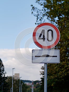 Vertical shot of a round speed limit 40 sign and a hump sign attached on a pole