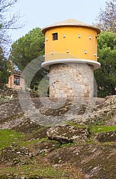 Vertical shot of a round yellow dovecote in a park in Plasencia