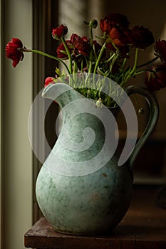 Vertical shot of a rustic vase of red roses
