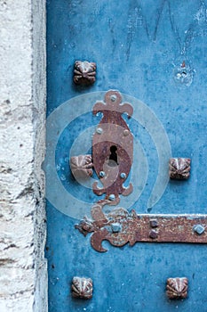 Vertical shot of a rusty blue door on a wooden exterior wall