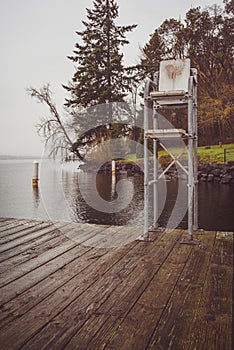 Vertical shot of a rusty old lifeguard seat on the dock of a lake