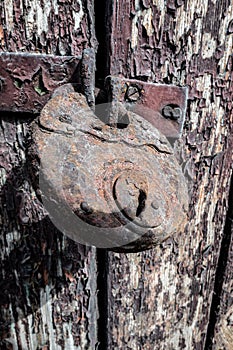 Vertical shot of a rusty old lock on a wooden door