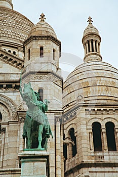 Vertical shot of Sacre Coeur basilica with the Jeanne d'Arc statue in Paris, Montmartre, France