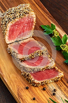 Vertical shot of Sesame crusted yellowfin tuna steak on wooden board