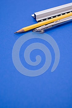 Vertical shot of a set of technical drawing tools on a blue background with a copy space