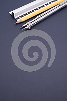 Vertical shot of a set of technical drawing tools on a blue background with a copy space