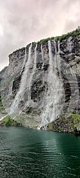 Vertical shot of the Seven Sisters Waterfall under cloudy sky in Stranda, More og Romsdal, Norway