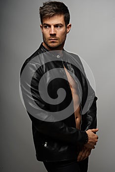 Vertical shot of a sexy topless male in a leather jacket