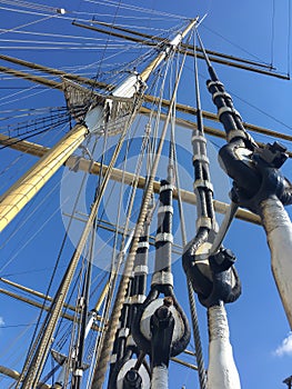 Vertical shot of ship masts under blue sky