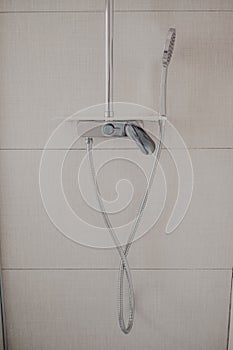 Vertical shot of the shower attached to the wall in a modern bathroom