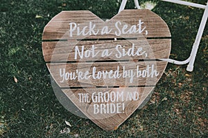 Vertical shot of signage, pick a seat either side on a wedding day with a blurred background.