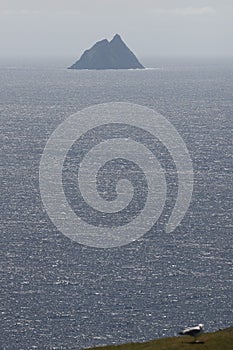 Vertical shot of a skellig island in the ocean in sunlight